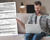 Mężczyzna z wściekłą miną trzyma dokumenty i laptopa, próbując zrozumieć formularz SD-Z2.