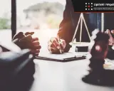 Prawnik podpisuje dokumenty, symbol sprawiedliwości i młotek sędziowski sugerują postępowanie egzekucyjne.