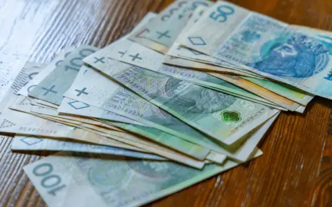 Stos banknotów 100 zł i 50 zł. Czy to wystarczy na najniższą krajową netto na godzinę?