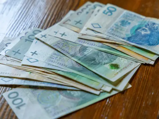 Stos banknotów 100 zł i 50 zł. Czy to wystarczy na najniższą krajową netto na godzinę?