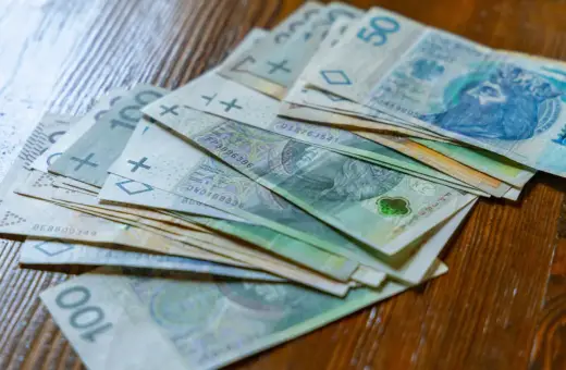 Stos banknotów 100 zł i 50 zł. Czy to wystarczy na najniższą krajową netto na godzinę?