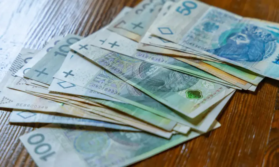 Stos banknotów 100 zł i 50 zł. Czy to wystarczy na najniższą krajową netto na godzinę?