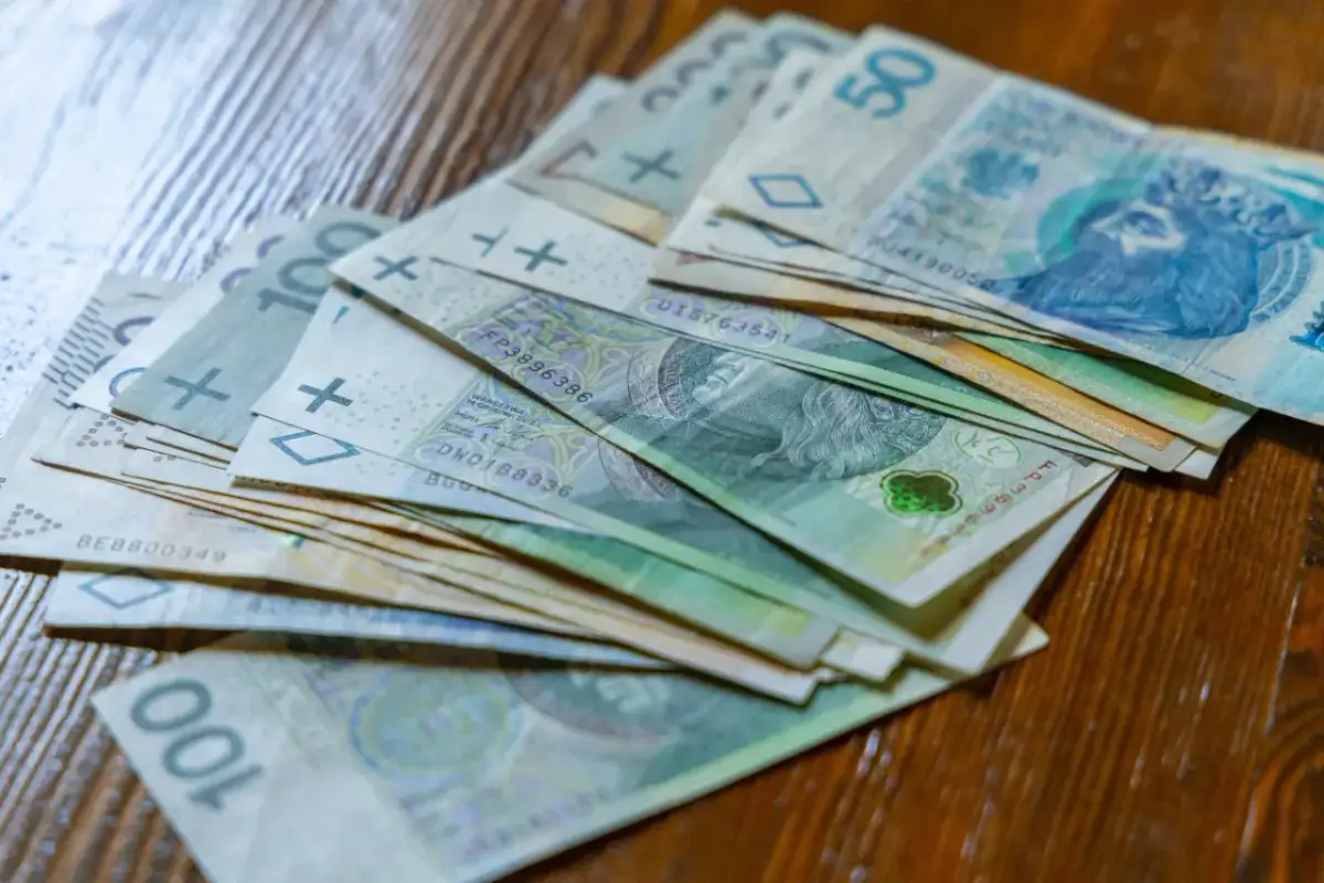 Stos banknotów 100 zł i 50 zł. Czy to wystarczy na najniższą krajową netto na godzinę?